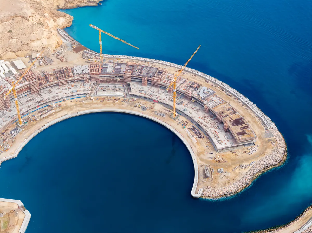 The Arc under construction, the curved concrete frame following the edge of the marina basin