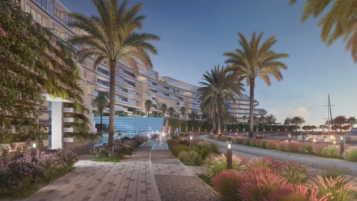 The marina promenade at The Arc, a planted walkway running along the waterfront at dusk