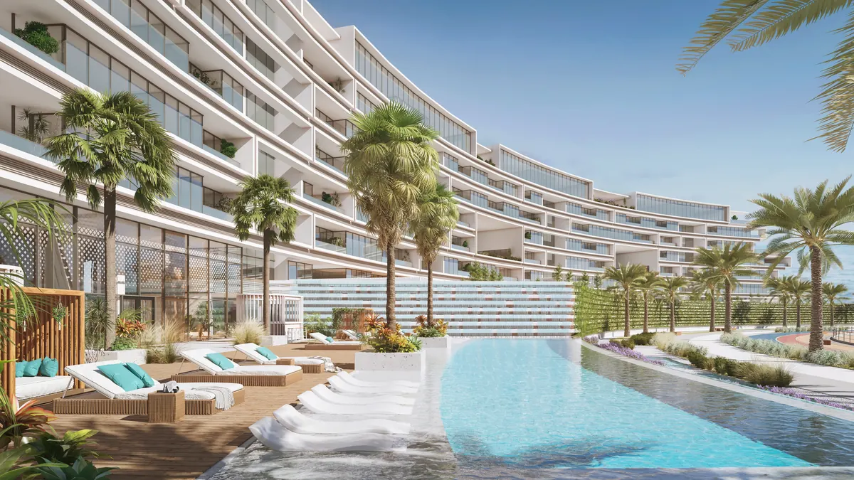 The residents pool at The Arc, a palm lined deck following the curve of the building
